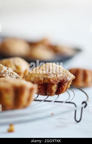 Muffins à la banane faits maison sur la grille de refroidissement du boulanger antique rustique au-dessus d'une table blanche. Mise au point sélective avec un premier plan et un arrière-plan flous. Banque D'Images