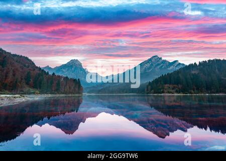 Vue d'automne paisible sur le lac Obersee dans les Alpes suisses. Coucher de soleil spectaculaire ciel et reflets de montagnes dans l'eau claire. Village de Nafels, Suisse. Photographie de paysage Banque D'Images