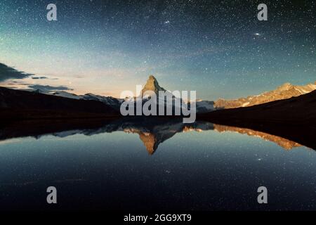 Vue de nuit incroyable lac Stellisee avec Cervin Cervin sommet dans les Alpes suisses. Des millions d'étoiles dans le pré-ciel lumineux. Zermatt resort lieu, en Suisse. L'astrophotographie paysage Banque D'Images