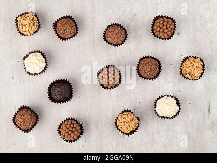 Brigadeiros brésilien typique, diverses saveurs sur une table en bois. Banque D'Images