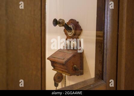 30 août 2021, Hessen, Bad Homburg VOR Der Höhe: Un téléphone, comme le Kaiser Wilhelm II l'aurait utilisé, est suspendu dans une cabine dans le château. Bad Homburg Palace abrite les seuls appartements impériaux encore en Allemagne. Après dix ans de restauration, la soi-disant aile royale doit être rouverte au public au début du mois de septembre. Photo: Andreas Arnold/dpa Banque D'Images