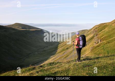 Backpacker appréciant la vue sur la coupe haute avec la vue sud vers un Fogg rempli Eden Valley, North Pennines, Cumbria, Royaume-Uni Banque D'Images