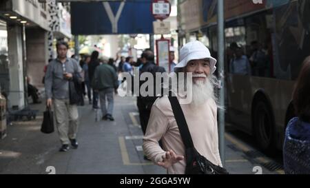 Vieux Chinois piéton avec long White Beard Nathan Road est le chemin de passage principal dans Yau Ma Tai, Mongkok, Kowloon, Hong Kong, Chine Banque D'Images