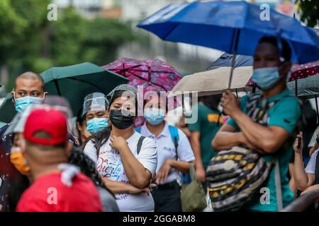 Quezon City, Philippines. 30 août 2021. Les personnes portant un masque facial attendent un trajet à la maison à Quezon City, aux Philippines, le 30 août 2021. Lundi, le ministère de la Santé des Philippines a signalé 22,366 nouveaux cas de COVID-19, soit la plus forte augmentation d'un jour depuis le début de la pandémie, ce qui porte le nombre total de cas confirmés dans le pays à 1,976,202. Le DOH a également enregistré 222 décès liés au coronavirus, ce qui porte le nombre de décès dans le pays à 33,330. Crédit: Rouelle Umali/Xinhua/Alamy Live News Banque D'Images