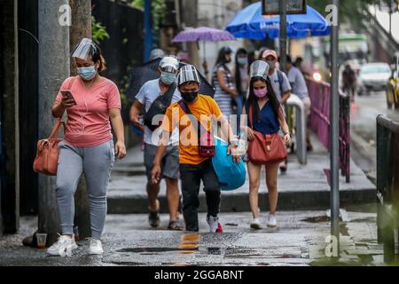 Quezon City, Philippines. 30 août 2021. Les personnes portant un masque facial marchent jusqu'à un arrêt de bus à Quezon City, aux Philippines, le 30 août 2021. Lundi, le ministère de la Santé des Philippines a signalé 22,366 nouveaux cas de COVID-19, soit la plus forte augmentation d'un jour depuis le début de la pandémie, ce qui porte le nombre total de cas confirmés dans le pays à 1,976,202. Le DOH a également enregistré 222 décès liés au coronavirus, ce qui porte le nombre de décès dans le pays à 33,330. Crédit: Rouelle Umali/Xinhua/Alamy Live News Banque D'Images