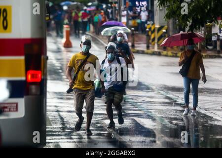 Quezon City, Philippines. 30 août 2021. Des personnes portant un masque facial courent pour un trajet en bus à Quezon City, aux Philippines, le 30 août 2021. Lundi, le ministère de la Santé des Philippines a signalé 22,366 nouveaux cas de COVID-19, soit la plus forte augmentation d'un jour depuis le début de la pandémie, ce qui porte le nombre total de cas confirmés dans le pays à 1,976,202. Le DOH a également enregistré 222 décès liés au coronavirus, ce qui porte le nombre de décès dans le pays à 33,330. Crédit: Rouelle Umali/Xinhua/Alamy Live News Banque D'Images