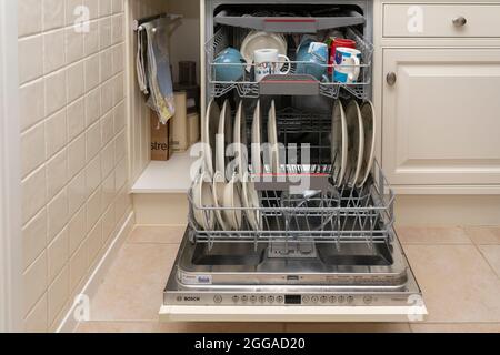 Un lave-vaisselle équipé plein de vaisselle propre lavée, des tasses et de la vaisselle dans une cuisine domestique à la maison Royaume-Uni, Grande-Bretagne Banque D'Images