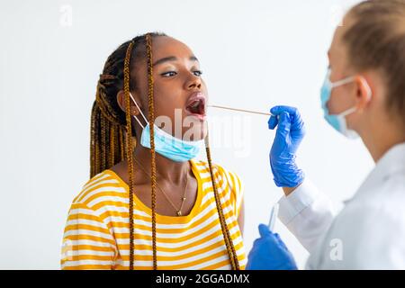 Afro-américaine qui obtient un test de dépistage oral du coronavirus à l'hôpital Banque D'Images