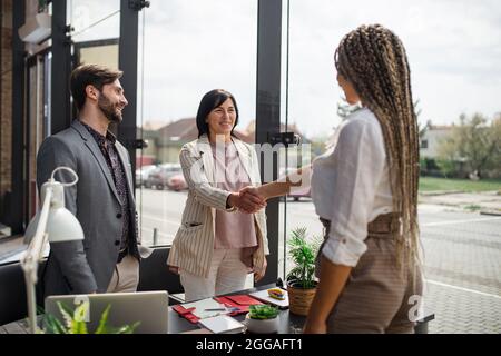 Jeune femme ayant un entretien d'emploi et se serrer la main dans le bureau, les affaires et le concept de carrière. Banque D'Images