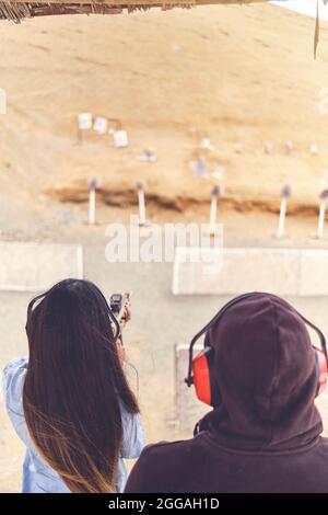 Femme libérant le stress, instructeur aidant la femme avec le pistolet Banque D'Images