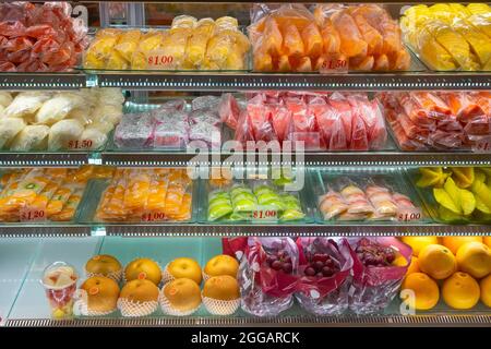 Variété de fruits tropicaux en tranches exposées dans un réfrigérateur exposé dans un magasin de cuisine de Singapour Banque D'Images
