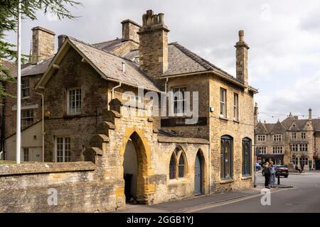 Le mur de la limite du chantier naval classé de catégorie II avec une porte d'entrée à l'église Saint-Édouard, dans le calcaire jaune traditionnel de Cotswold. Rangez-vous sur la vieille Banque D'Images