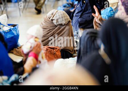 Ramstein Miesenbach, Allemagne. 30 août 2021. Les femmes évacuées d'Afghanistan s'assoient dans un hangar converti en salon de départ à la base aérienne de Ramstein. Les États-Unis utilisent également leur base militaire à Ramstein, dans le Palatinat, comme centre d'évacuation des demandeurs d'abris et des forces locales d'Afghanistan. Credit: Uwe Anspach/dpa/Alamy Live News Banque D'Images