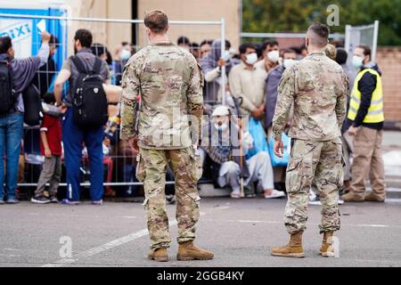 Ramstein Miesenbach, Allemagne. 30 août 2021. Les soldats AMÉRICAINS se tiennent devant des personnes évacuées d'Afghanistan à la base aérienne de Ramstein. Les États-Unis utilisent également leur base militaire à Ramstein, dans le Palatinat, comme un centre d'évacuation des personnes cherchant à se protéger et des forces locales d'Afghanistan. Credit: Uwe Anspach/dpa/Alamy Live News Banque D'Images