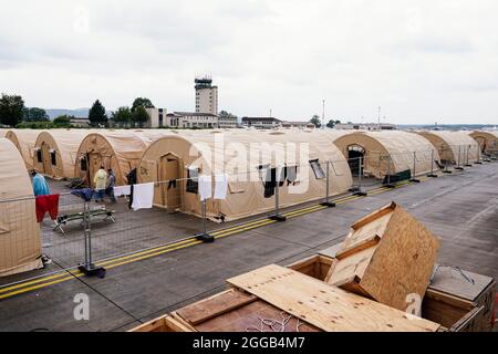 Ramstein Miesenbach, Allemagne. 30 août 2021. Les personnes évacuées d'Afghanistan se tiennent entre des tentes à la base aérienne de Ramstein. Les États-Unis utilisent également leur base militaire à Ramstein, dans le Palatinat, comme un centre d'évacuation des personnes cherchant à se protéger et des forces locales d'Afghanistan. Credit: Uwe Anspach/dpa/Alamy Live News Banque D'Images