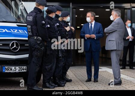 Essen, Allemagne. 30 août 2021. Armin Laschet (2e en partant de la droite), Ministre-Président de la Rhénanie-du-Nord-Westphalie, Président fédéral et candidat pour le Chancelier de la CDU, et Herbert Reul (r, CDU), Ministre de l'intérieur de la Rhénanie-du-Nord-Westphalie, échangent leurs vues avec les policiers de l'équipe de police anti-émeute. Les deux hommes politiques ont fait le point sur la lutte contre la criminalité des clans et ont présenté une photo de la situation de la criminalité des clans en 2020. Credit: Rolf Vennenbernd/dpa/Alay Live News Banque D'Images