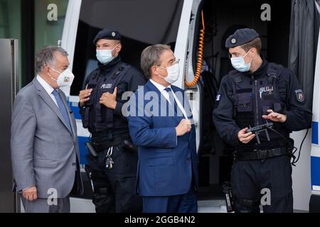 Essen, Allemagne. 30 août 2021. Armin Laschet (2e en partant de la droite), Ministre-Président de la Rhénanie-du-Nord-Westphalie, Président fédéral et candidat pour le Chancelier de la CDU, et Herbert Reul (l, CDU), Ministre de l'intérieur de la Rhénanie-du-Nord-Westphalie, échangent leurs vues avec les policiers de l'équipe de police anti-émeute. Les deux hommes politiques ont fait le point sur la lutte contre la criminalité des clans et ont présenté une photo de la situation de la criminalité des clans en 2020. Credit: Rolf Vennenbernd/dpa/Alay Live News Banque D'Images