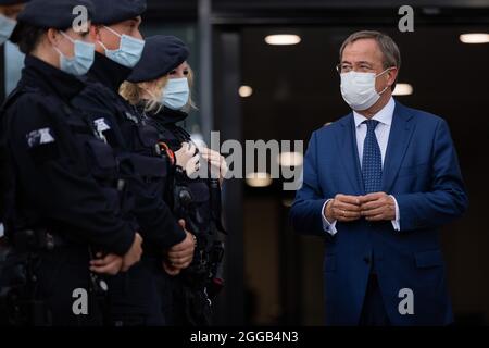 Essen, Allemagne. 30 août 2021. Armin Laschet (r), Ministre-Président de la Rhénanie-du-Nord-Westphalie, Président fédéral et candidat au poste de Chancelier de la CDU, échange des vues avec les policiers de l'équipe de police anti-émeute. Laschet et H. Reul (CDU), ministre de l'intérieur de la Rhénanie-du-Nord-Westphalie, ont fait le point sur la lutte contre la criminalité des clans et ont présenté un rapport de situation sur la criminalité des clans en 2020. Credit: Rolf Vennenbernd/dpa/Alay Live News Banque D'Images