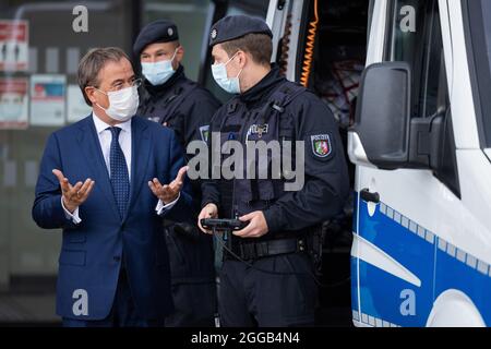 Essen, Allemagne. 30 août 2021. Armin Laschet (l), Ministre-Président de la Rhénanie-du-Nord-Westphalie, Président fédéral et candidat au poste de Chancelier de la CDU, échange des vues avec les policiers de l'équipe de police anti-émeute. Laschet et H. Reul (CDU), ministre de l'intérieur de la Rhénanie-du-Nord-Westphalie, ont fait le point sur la lutte contre la criminalité des clans et ont présenté un rapport de situation sur la criminalité des clans en 2020. Credit: Rolf Vennenbernd/dpa/Alay Live News Banque D'Images