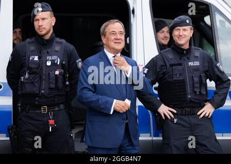 Essen, Allemagne. 30 août 2021. Armin Laschet (M), Ministre-Président de la Rhénanie-du-Nord-Westphalie, Président fédéral et candidat au poste de Chancelier de la CDU, échange des vues avec les policiers de l'équipe de police anti-émeute. Laschet et H. Reul (CDU), ministre de l'intérieur de la Rhénanie-du-Nord-Westphalie, ont fait le point sur la lutte contre la criminalité des clans et ont présenté une photo de la situation de la criminalité des clans en 2020. Credit: Rolf Vennenbernd/dpa/Alay Live News Banque D'Images