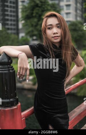 Portrait de la belle fille asiatique en robe noire décontractée debout dans le parc. Belle allure. Jolie femme vietnamienne. Photo de haute qualité Banque D'Images