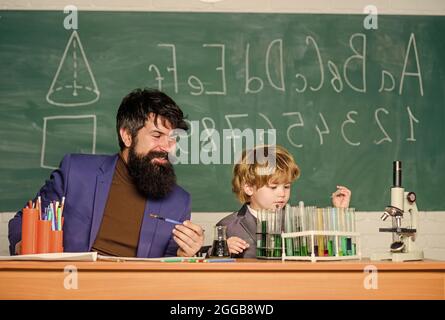 Jouez avec des liquides. Professeur et laboratoire de chimie de garçon. Exemple personnel inspirant. Connaissances scolaires. Journée de la connaissance vacances de septembre. Niveau de base Banque D'Images