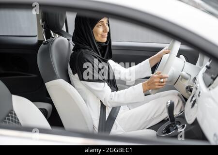 Une femme musulmane conduit une voiture Banque D'Images