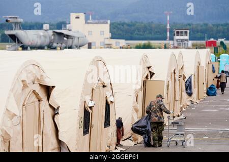 Ramstein Miesenbach, Allemagne. 30 août 2021. Un soldat américain passe devant une rangée de tentes avec une voiturette à la base aérienne de Ramstein. Les États-Unis utilisent également leur base militaire à Ramstein, dans le Palatinat, comme centre d'évacuation des demandeurs d'abris et des forces locales d'Afghanistan. Credit: Uwe Anspach/dpa/Alamy Live News Banque D'Images