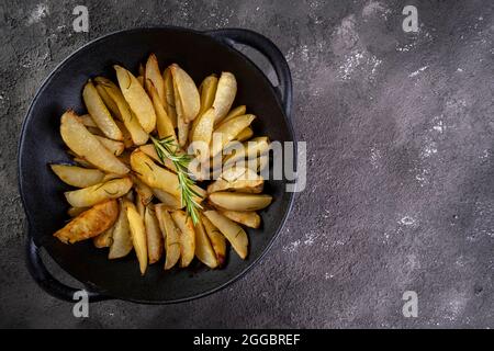 Pommes de terre cuites dans une casserole de fer avec du romarin et de l'huile d'olive. Banque D'Images