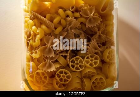 Mélanger les pâtes dans un pot en verre. Les pâtes Lumaconi, Cavatappi, Farfalle et Rotelle se mélangent dans un pot en verre. Banque D'Images