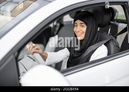 Une femme musulmane conduit une voiture Banque D'Images