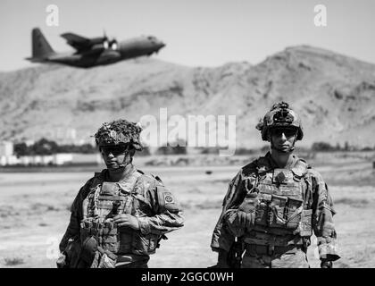 Deux parachutistes affectés à l'équipe de combat de la 1re Brigade, la 82e Division aéroportée, effectuent la sécurité tandis qu'un Hercules C-130 part lors d'une opération d'évacuation non combattue à Kaboul, en Afghanistan, en août 25. Le ministère de la Défense aide le ministère d'État à évacuer le personnel civil des États-Unis, les demandeurs de visa d'immigrant spécial et les autres personnes à risque d'Afghanistan le plus rapidement et en toute sécurité possible. (Photo de courtoisie du DoD) Banque D'Images