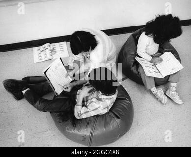 Austin Texas USA, 1988 : enseignant hispanique de l'éducation spéciale travaille en tête-à-tête avec l'élève tout en étant assis sur le sol dans la salle de classe. MR RR-0177 ©Bob Daemmrich Banque D'Images