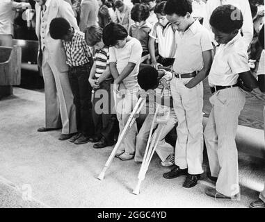 Austin Texas USA, 1984 : Patrick Skeaton, étudiant noir de quatrième année, qui a perdu sa jambe droite à cause du spina bifida, utilise des béquilles en bois pour se déplacer à l'école primaire Wooten à Austin, Texas, tout en étant intégré dans la salle de classe ordinaire. Il a ensuite été équipé d'une prothèse de jambe. Fait partie d'une fonction photo étendue. ©Bob Daemmrich Banque D'Images