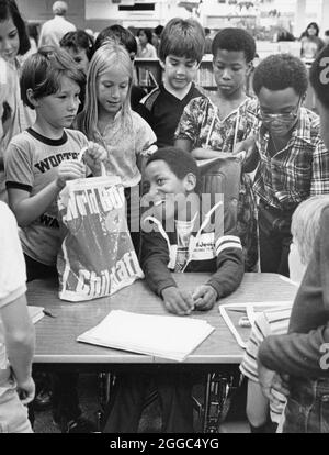 Austin Texas USA, 1984 : Patrick Skeaton, étudiant noir de quatrième année, qui a perdu sa jambe droite à cause du spina bifida, interagit avec ses camarades de classe à l'école primaire Wooten tout en étant intégré dans la salle de classe ordinaire. Il a ensuite été équipé d'une prothèse de jambe. Fait partie d'une fonction photo étendue. ©Bob Daemmrich Banque D'Images