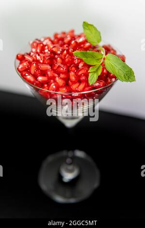 Graines de grenade saines dans un verre à cocktail à la menthe Banque D'Images