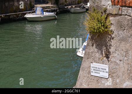 Un canal dans le quartier caractéristique de la Nouvelle Venise avec un signe modifié de manière géliardique avec le sens typique de l'humour toscan, Livourne, Toscane Banque D'Images