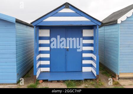 30 août 2021 - Essex, Royaume-Uni : cabane de plage à rayures bleues et blanches en bord de mer Banque D'Images