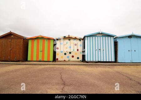 30 août 2021 - Essex, Royaume-Uni: Rangée de cabanes de plage à rayures et à pois Banque D'Images