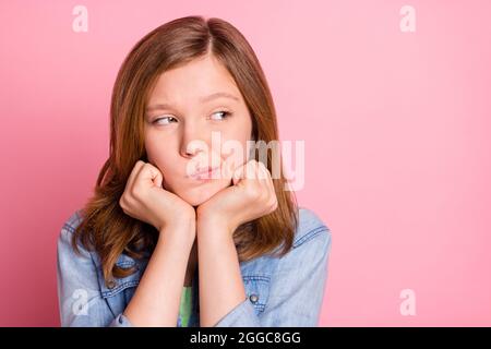 Photo de la jeune fille mains toucher le menton penser le rêve réfléchi look vide espace isolé sur fond rose couleur Banque D'Images