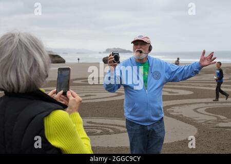 Denny Dyke, artiste du sable, parle à la foule à l'ouverture de son labyrinthe de sable, à Bandon, Oregon, États-Unis. Banque D'Images