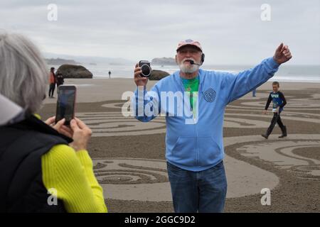 Denny Dyke, artiste du sable, parle à la foule à l'ouverture de son labyrinthe de sable, à Bandon, Oregon, États-Unis. Banque D'Images