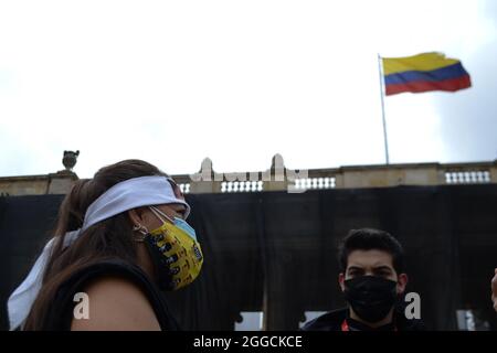 Bogota, Colombie. 30 août 2021. Une mère d'un 'faux positif' donne une interview pendant que le drapeau colombien est brandi, lors de la performance effectuée sur la Plaza de Bolívar par des militants universitaires et des mères des 'faux positifs' (meurtres de civils innocents passés comme victimes de guérilla au combat) à Bogota, Colombie le 30 août, 2021 crédit : long Visual Press/Alamy Live News Banque D'Images