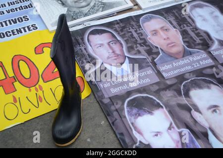 Bogota, Colombie. 30 août 2021. Des bottes noires et des portraits d'hommes innocents assassinés ont été exposés lors de la représentation effectuée sur la Plaza de Bolivar par des militants universitaires et des mères des « faux positifs » (meurtres de civils innocents passés victimes de guérilla au combat) à Bogota, Colombie le 30 août à partir de 2021 crédit : Long Visual Press/Alamy Live News Banque D'Images