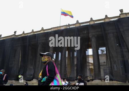 Bogota, Colombie. 30 août 2021. Une mère d'un « faux positif » se tient debout, tandis que le drapeau colombien est brandi, lors de la représentation effectuée sur la Plaza de Bolivar par des militants universitaires et des mères des « faux positifs » (meurtres de civils innocents morts de guérilleros au combat) à Bogota, en Colombie, le 30 août, 2021 crédit : long Visual Press/Alamy Live News Banque D'Images