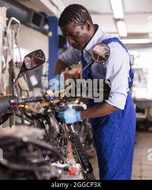 Technicien de service réparant la moto en service Banque D'Images