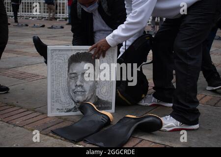 Bogota, Colombie. 30 août 2021. Un proche parent place un dessin d'Oscar Alexander un jeune homme tué lors de la commémoration de la journée internationale des victimes de la disparition de la force comme mères et proches parents de jeunes tués dans des "faux positifs" (Falsos Positivos) en Colombie, se produire sur la Plaza de Bolivar à Bogota, Colombie le 30 août 2021. Crédit : long Visual Press/Alamy Live News Banque D'Images