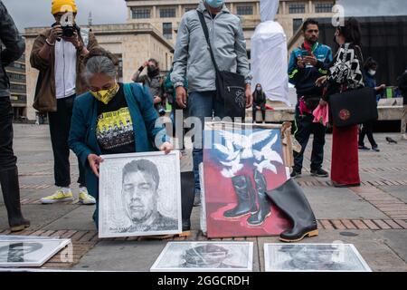 Bogota, Colombie. 30 août 2021. Un proche parent place un dessin d'Oscar Alexander un jeune homme tué lors de la commémoration de la journée internationale des victimes de la disparition de la force comme mères et proches parents de jeunes tués dans des "faux positifs" (Falsos Positivos) en Colombie, se produire sur la Plaza de Bolivar à Bogota, Colombie le 30 août 2021. Crédit : long Visual Press/Alamy Live News Banque D'Images