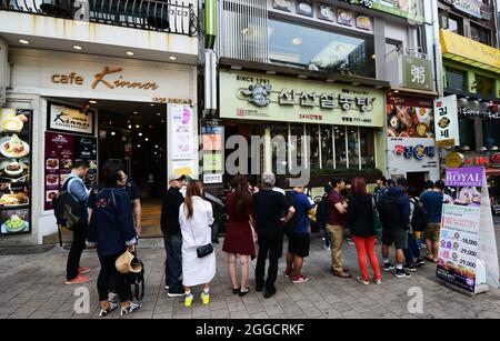 Les visiteurs font la queue devant le restaurant sinseon seolnongtang dans le quartier commerçant de Myeongdong à Séoul, en Corée du Sud. Banque D'Images