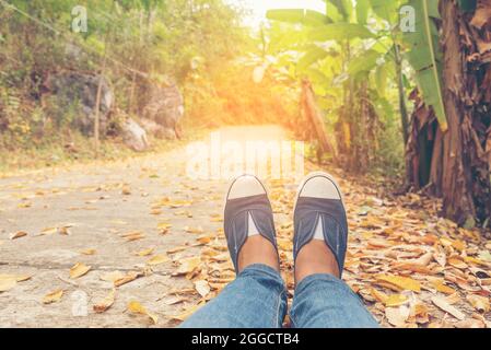 Chaussures de randonnée jeune femme voyageur s'assoit sur le parc d'été.concentrez-vous sur les chaussures de basket bleues et les jeans sur le sentier. Activité active vacances sur la montagne de randonnée Banque D'Images